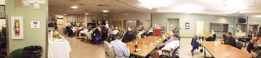A group of older adults enjoying a social gathering in a casual indoor setting.