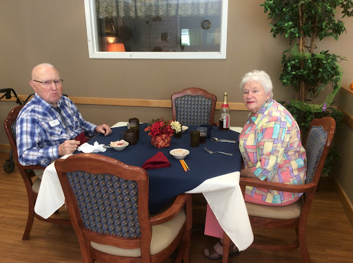 An elderly couple enjoying a meal together in a cozy dining setting.