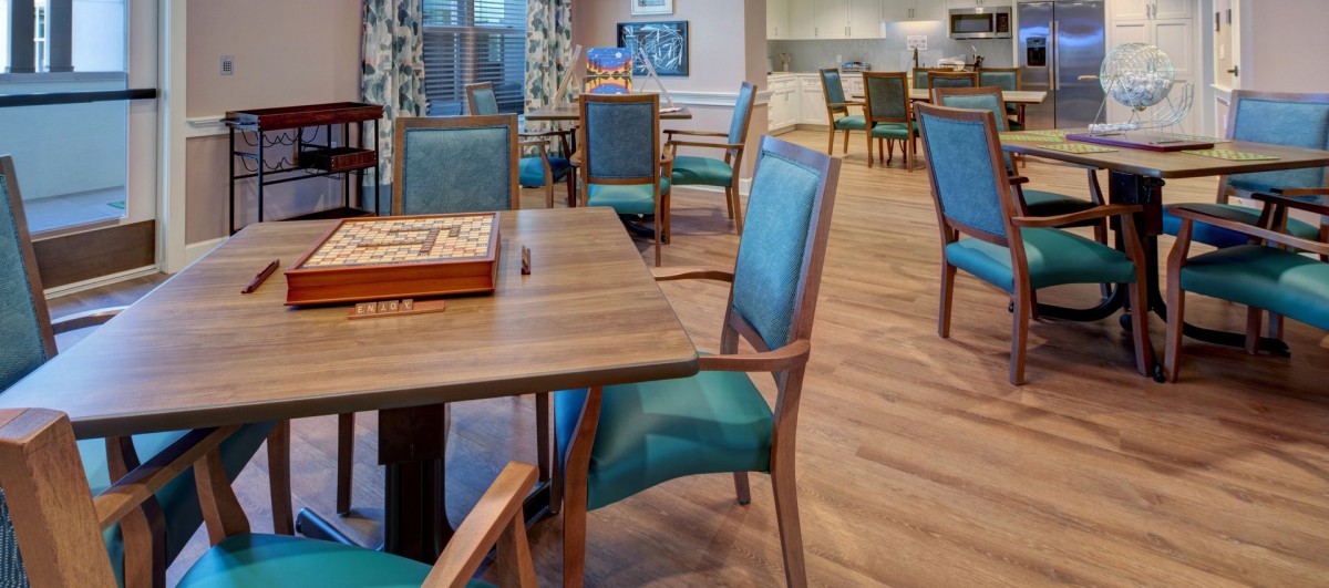A cozy dining room with wooden tables and upholstered chairs.