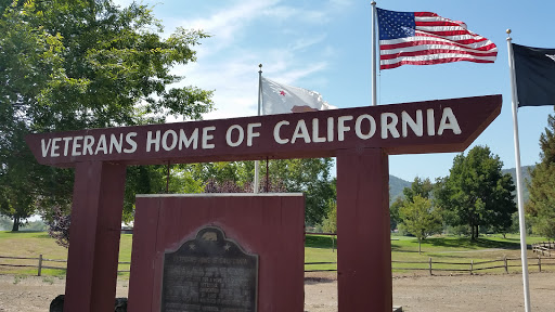 A sign marking a historical site in California, adorned with the American flag.