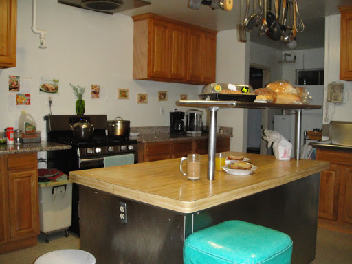 A cozy kitchen featuring a wooden island countertop with food items and modern appliances.