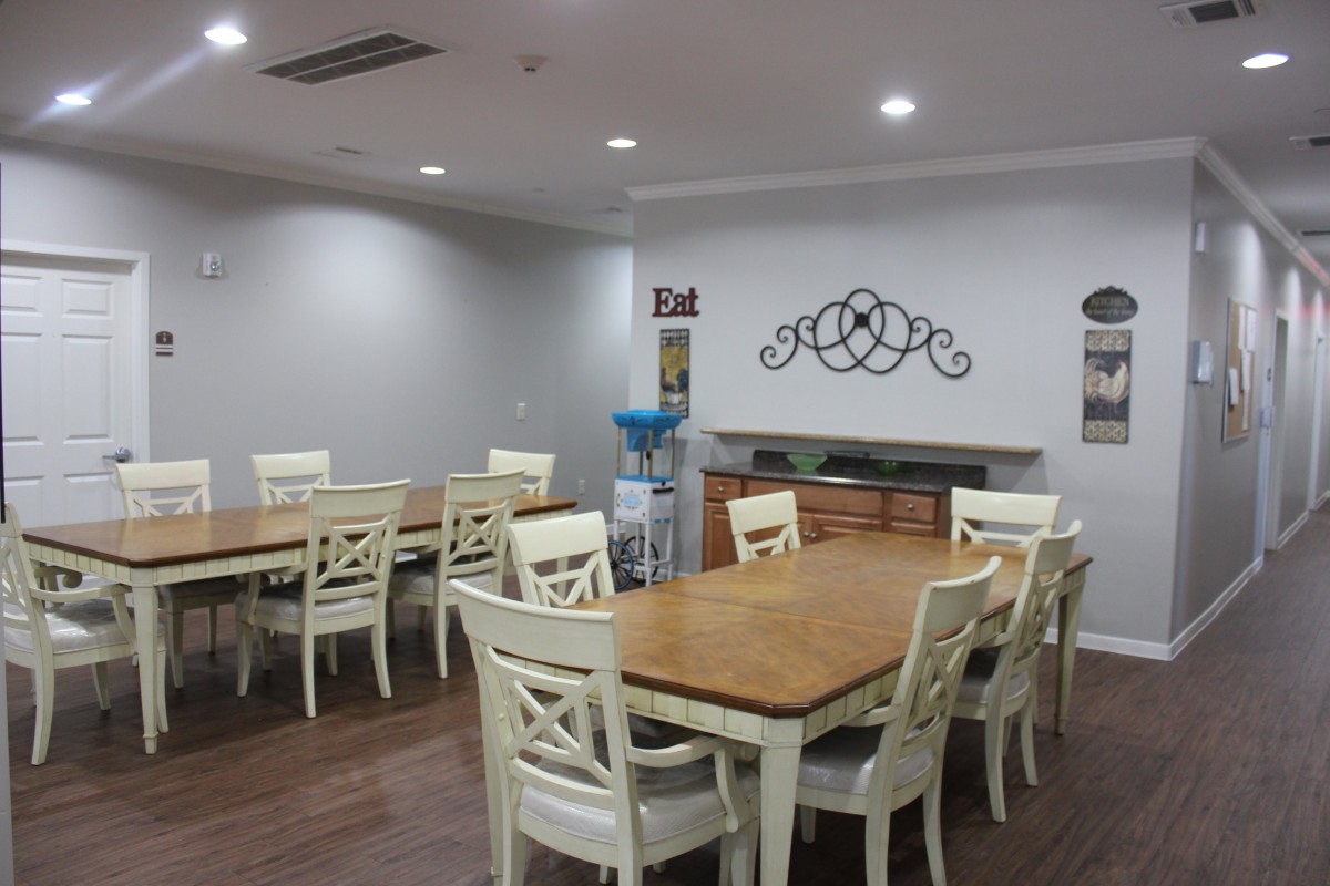 A cozy dining area with wooden tables and white chairs, complemented by modern decor and lighting.