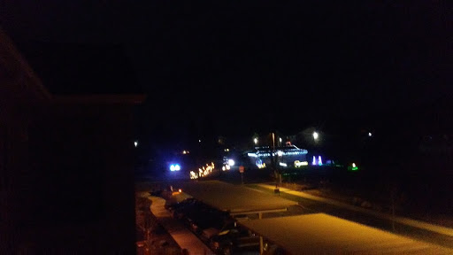A nighttime view of a street decorated with colorful lights.