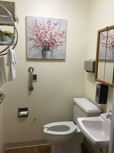 A well-equipped bathroom featuring a floral artwork, functional amenities, and accessibility features.