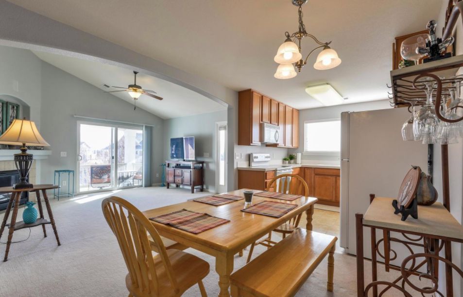 A bright and open dining area adjacent to a cozy kitchen with wooden furniture.