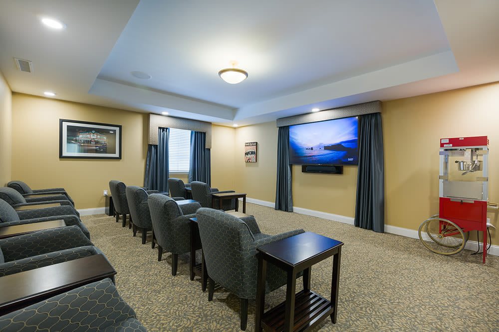 A cozy home theater setup with multiple seating rows and a large screen.