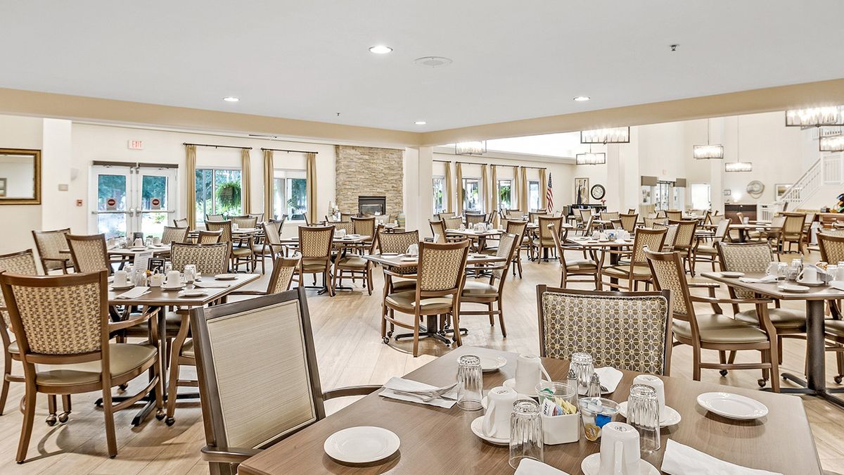 A spacious and elegantly designed dining area with neatly set tables and chairs.