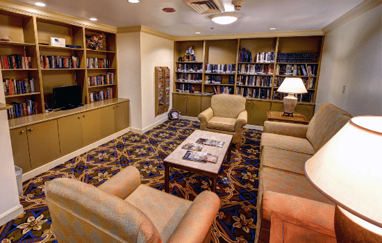 A cozy library reading room with armchairs and bookshelves.