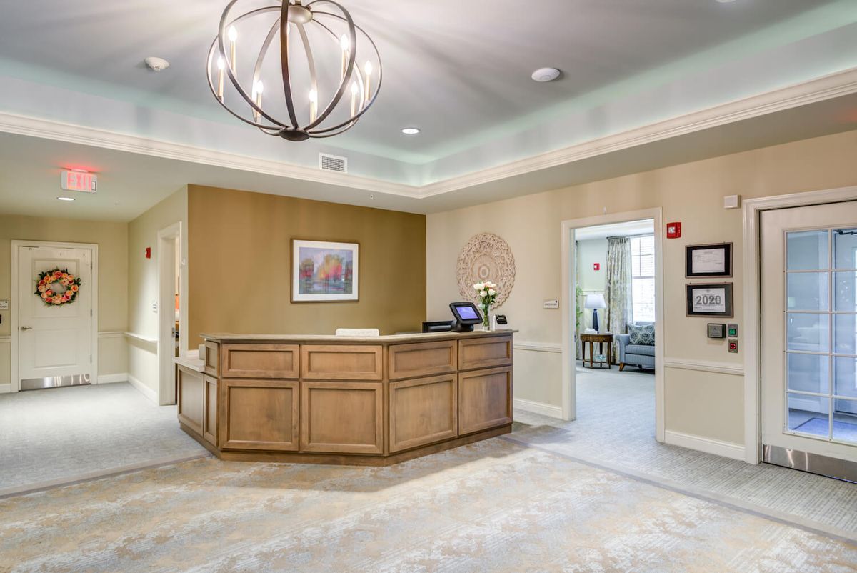A modern reception area with a wooden desk and stylish lighting.