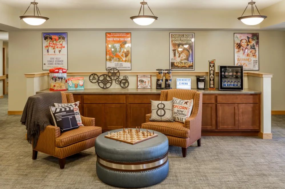 A cozy lounge area with comfortable chairs, movie-themed decorations, and a small refreshment station.