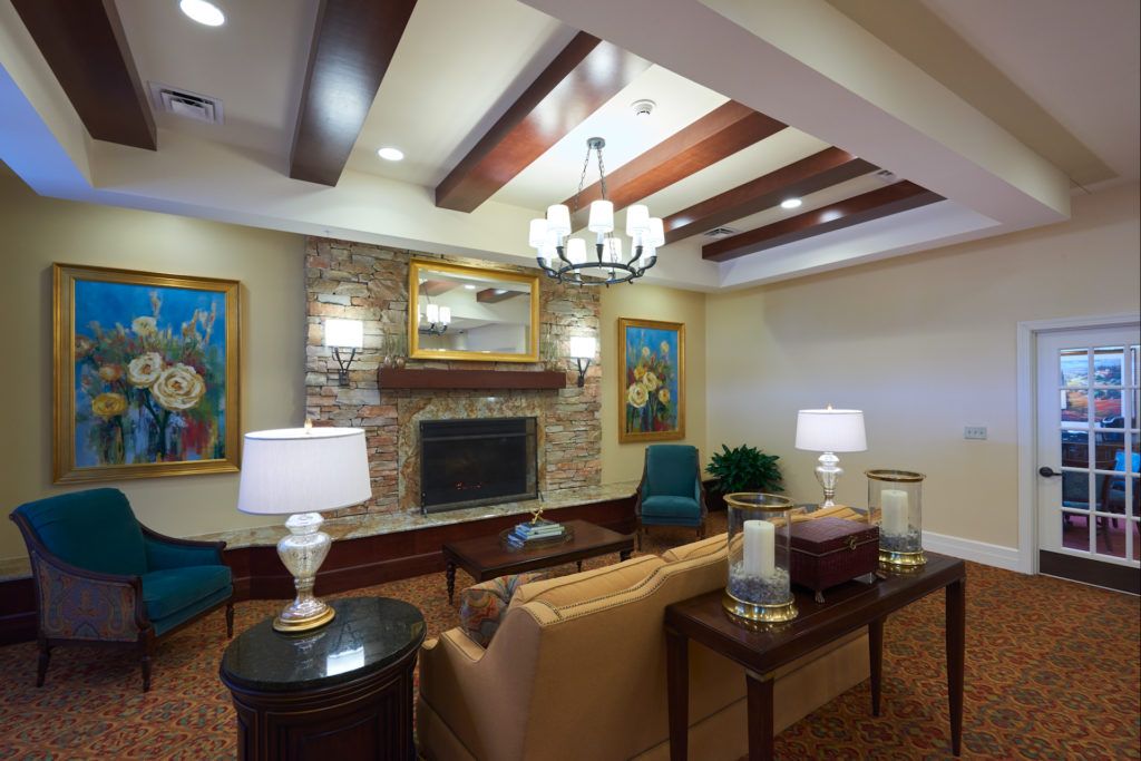A cozy living room with a fireplace, elegant furniture, and decorative ceiling beams.