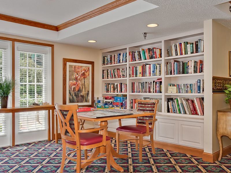 Cozy library reading area with a table and chairs surrounded by bookshelves.
