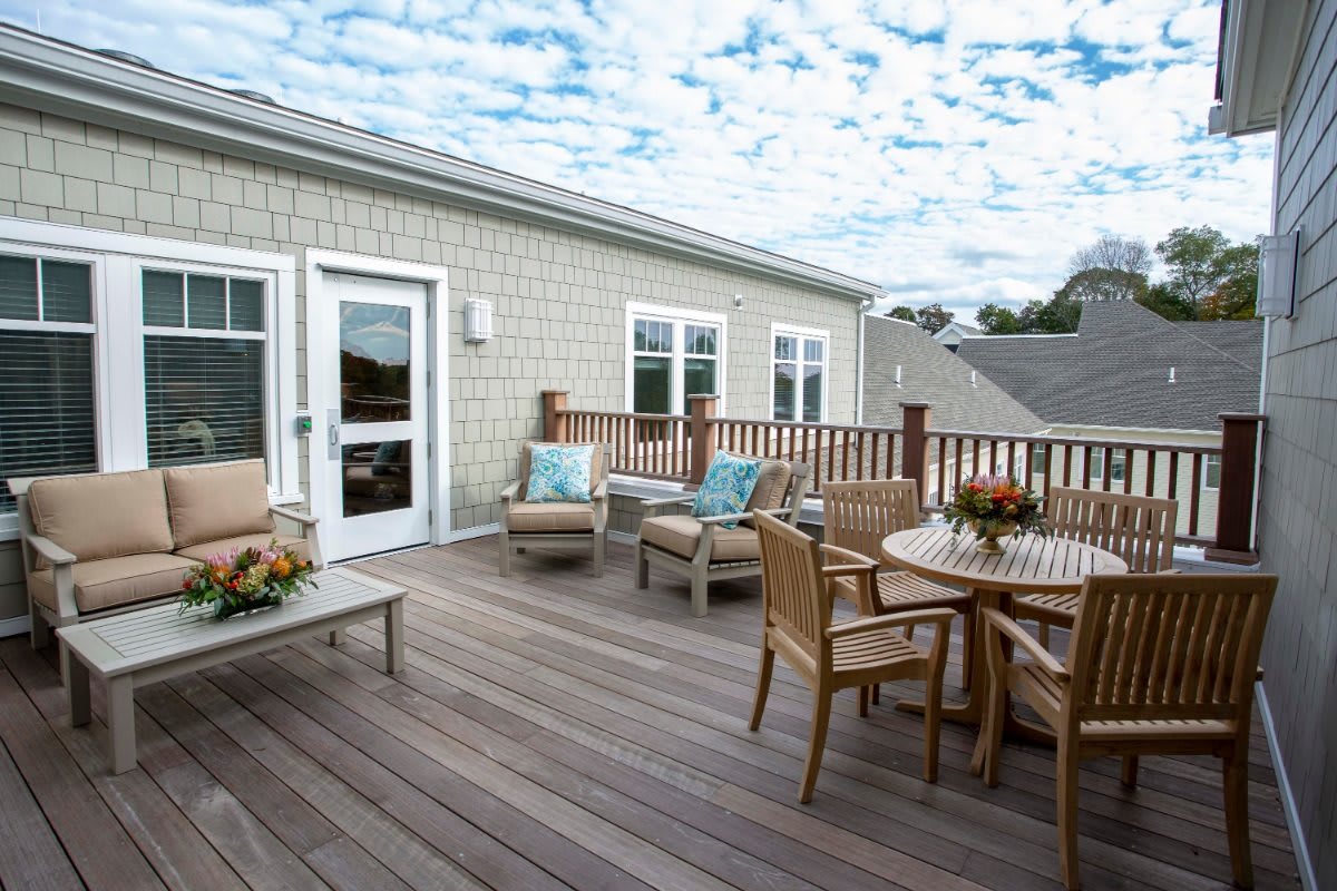 A cozy outdoor deck with comfortable seating and a dining area, perfect for relaxation.