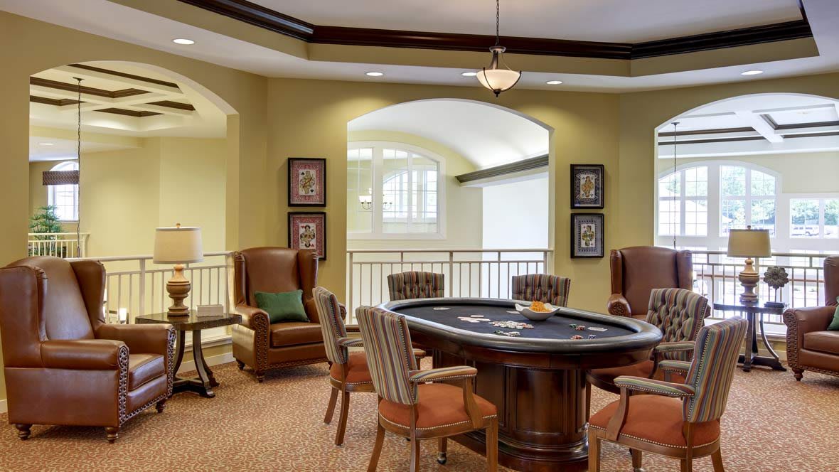A luxurious lounge with a poker table and comfortable seating.