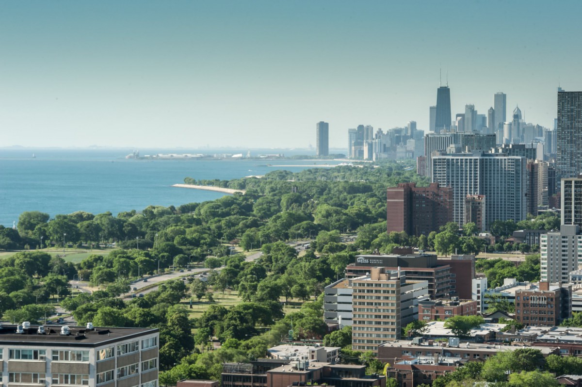 A vibrant city skyline with a mix of urban buildings, lush green parks, and a scenic waterfront.