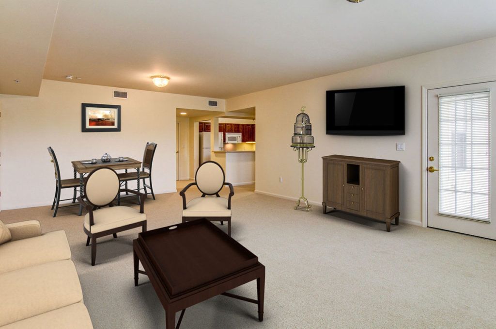 A spacious living room with modern furniture and a flat-screen TV, adjacent to a dining area.