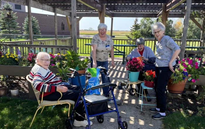 A group of seniors enjoying gardening activities outdoors.