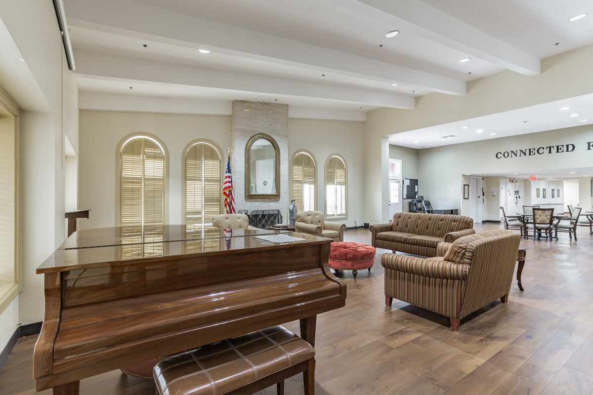 A spacious lobby featuring a piano, comfortable seating, and elegant decor.