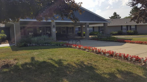 A bright and inviting community center surrounded by colorful flowers.