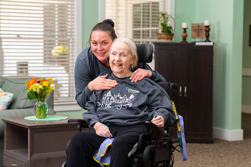 A joyful moment shared between a caregiver and an elderly resident, highlighting the importance of companionship and care.