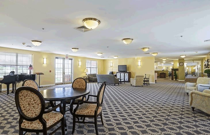 A spacious and well-lit lounge area with comfortable seating arrangements and patterned carpeting.