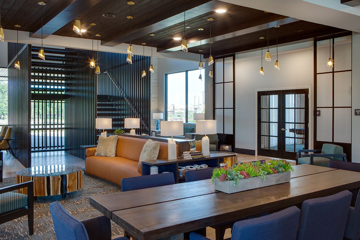 A modern living room with stylish furniture, featuring an open floor plan and elegant lighting.