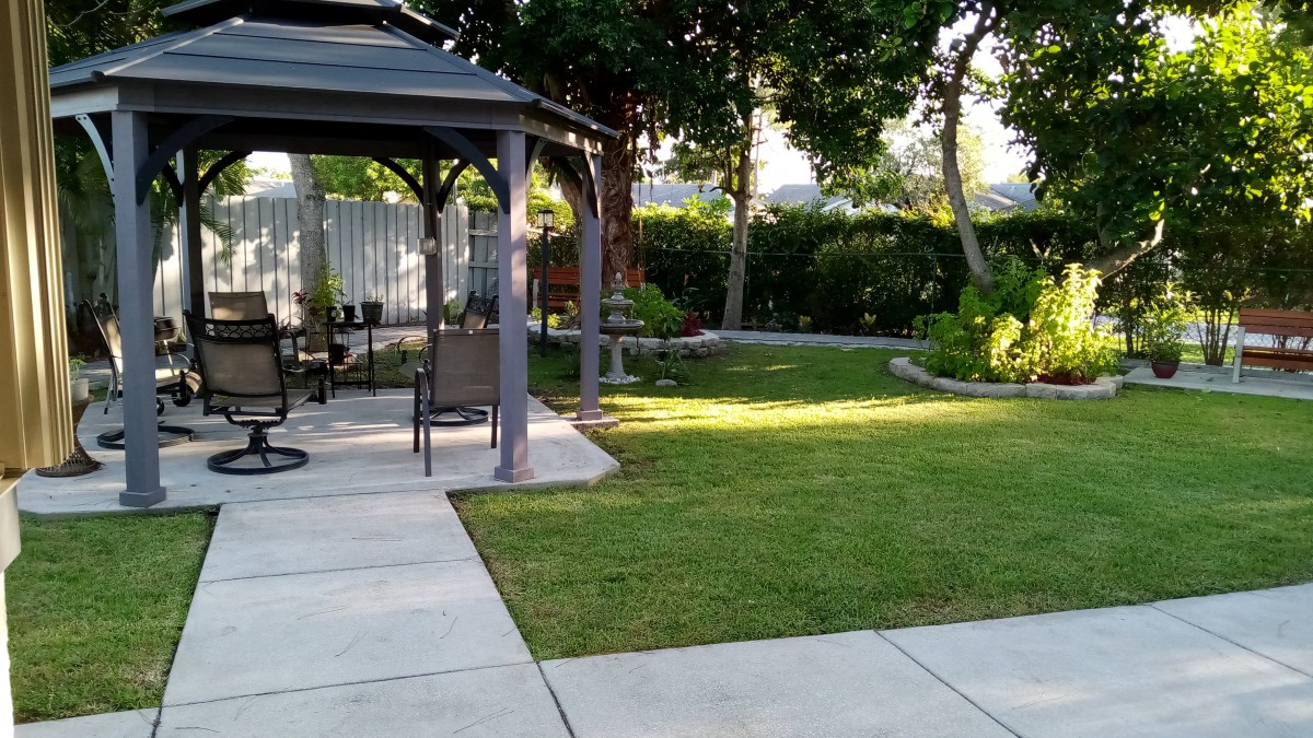 A peaceful garden with a gazebo and well-maintained lawn.
