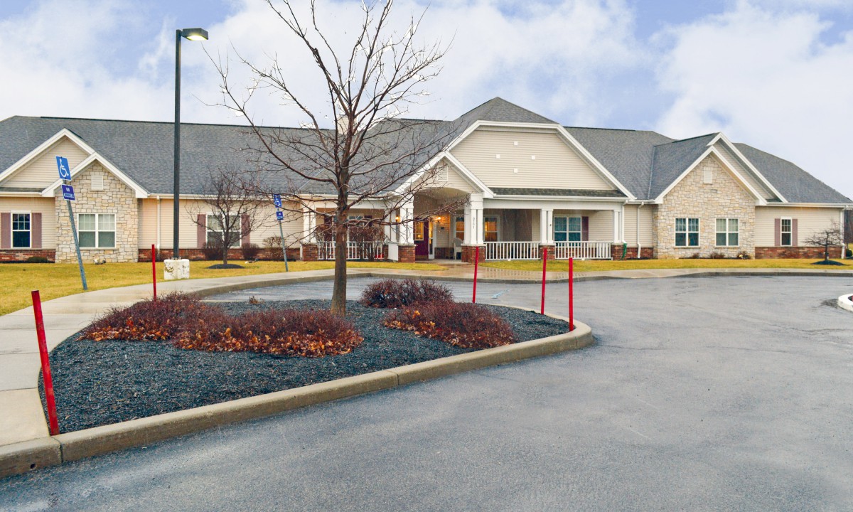 A suburban building with a parking lot and landscaped entrance.