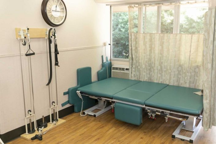 A physical therapy room equipped with exercise mats and various rehabilitation tools.