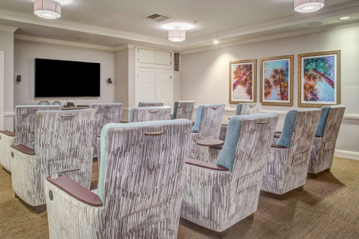 A modern conference room with arranged seating and a large screen, designed for meetings.