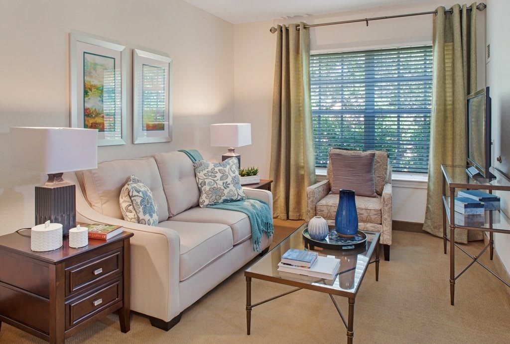 A cozy living room with a sofa, armchair, and a coffee table adorned with decorative items.