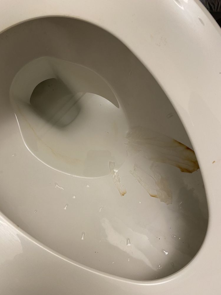 A toilet with visible stains on the bowl.