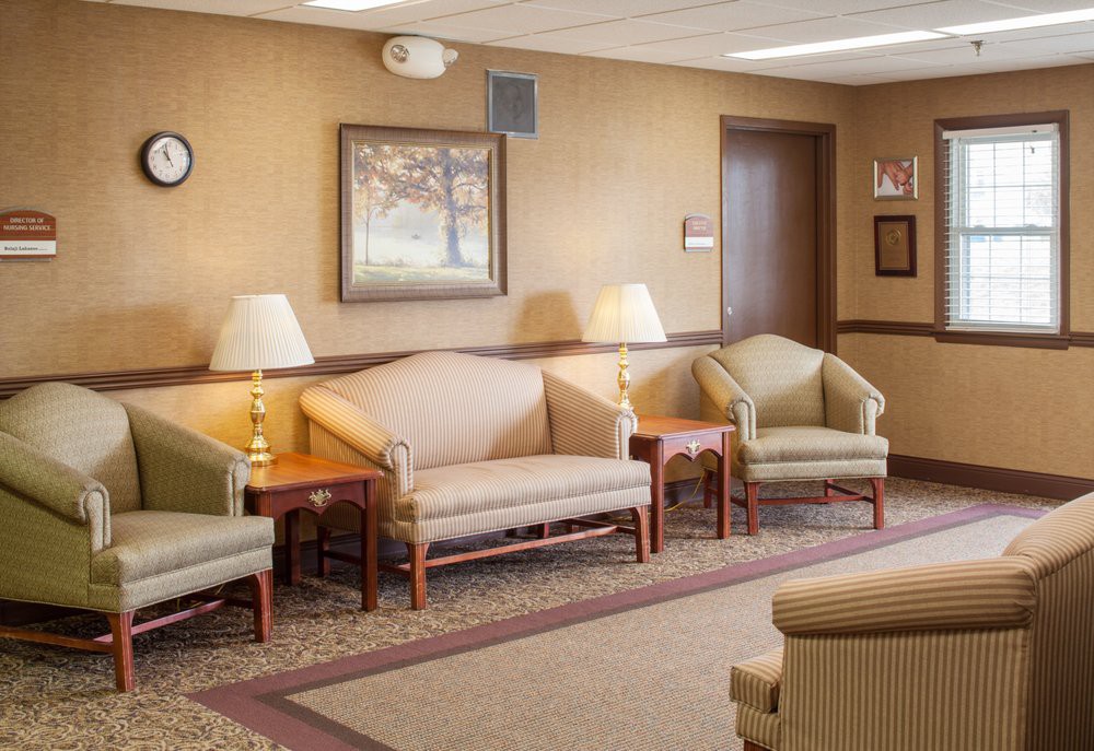 A cozy waiting room with sofas, chairs, and lamps.