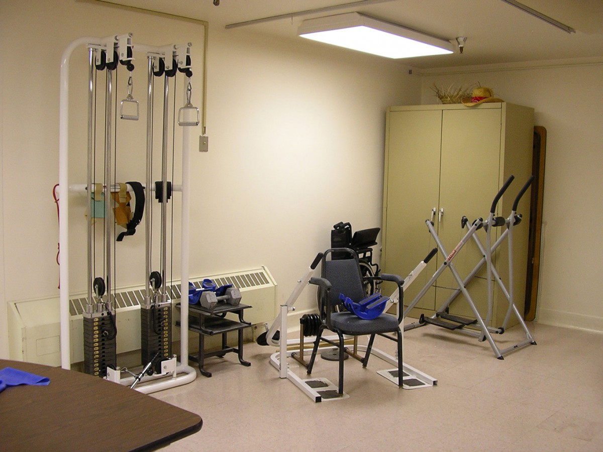 A rehabilitation room equipped with exercise machines and therapy tools.