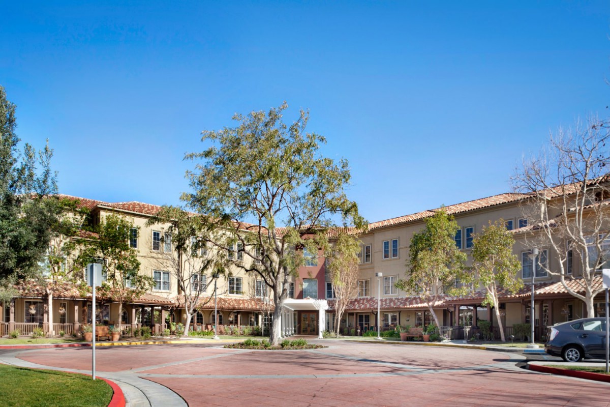 A sunny day at a modern residential building complex surrounded by trees.