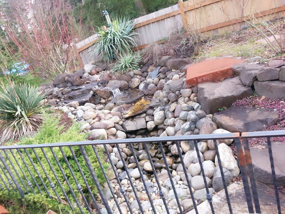 A beautifully landscaped rock garden featuring a natural water feature.