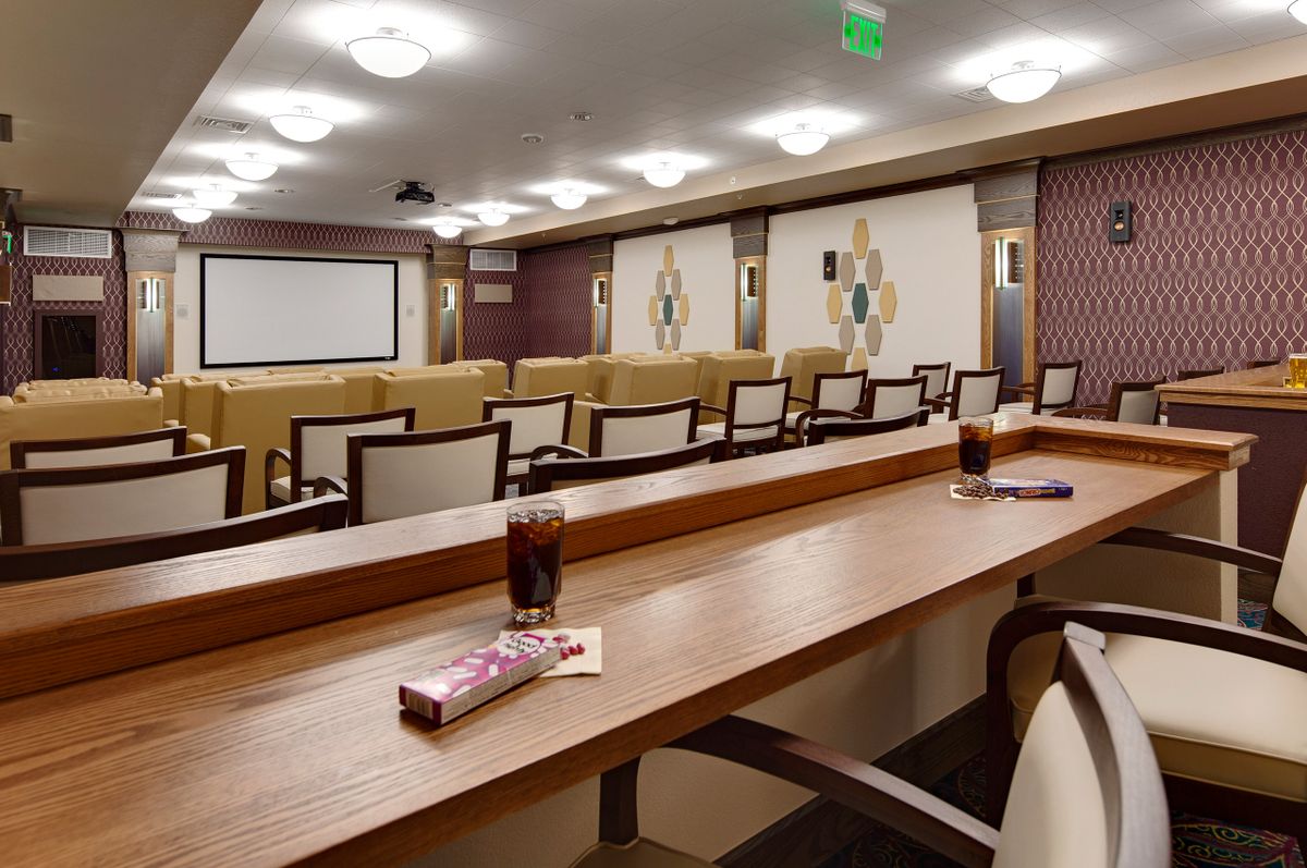 A well-equipped conference room with arranged seating and drinks on the tables, ready for a presentation.