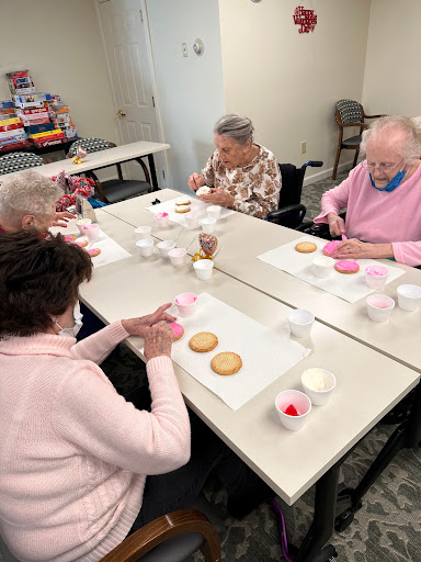 Seniors enjoying a fun cookie decorating activity together.