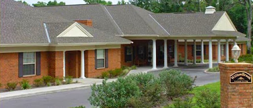 A cozy residential building featuring brick architecture and a well-maintained landscape.