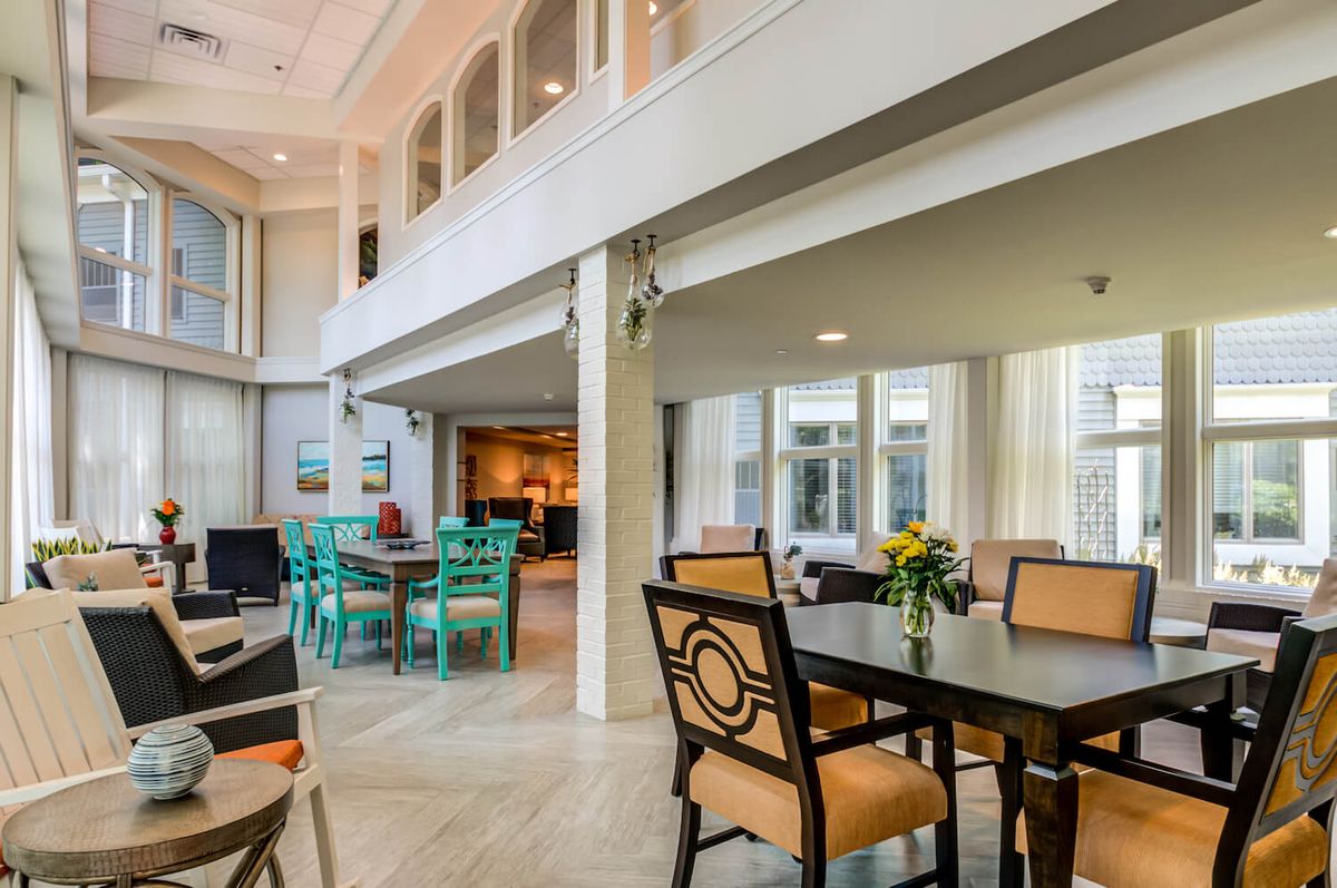 A spacious, brightly lit dining area with multiple tables and colorful chairs.