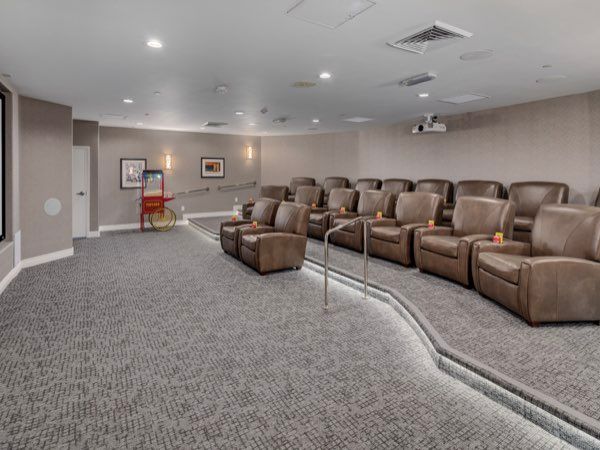 A cozy home theater with reclining seats and a projector screen.