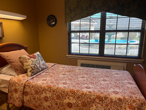 A cozy bedroom featuring floral bedding and a view of the outdoors.