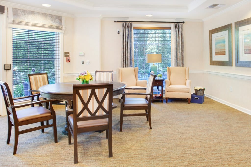 A cozy living space with a table, chairs, and large windows.