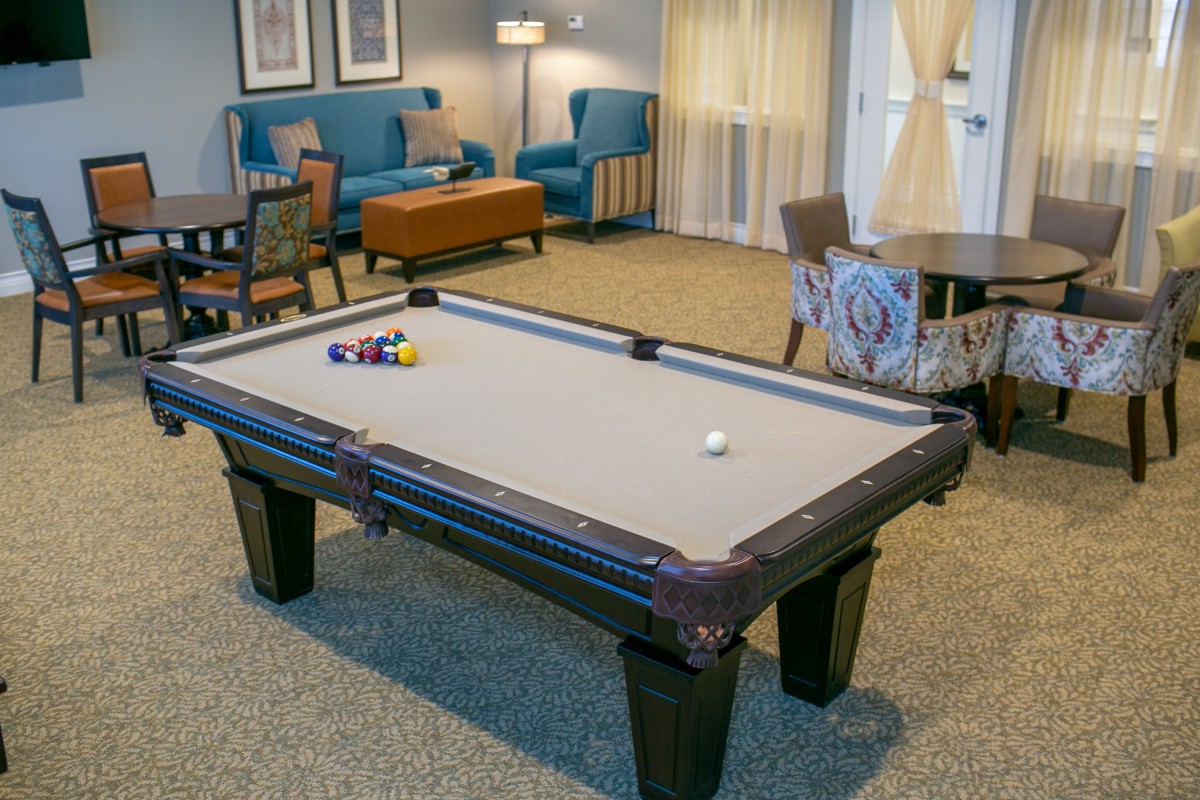 A cozy recreation room featuring a pool table and comfortable seating.