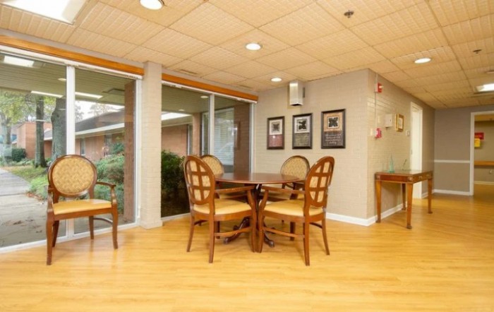A cozy dining area with wooden furniture and large windows.