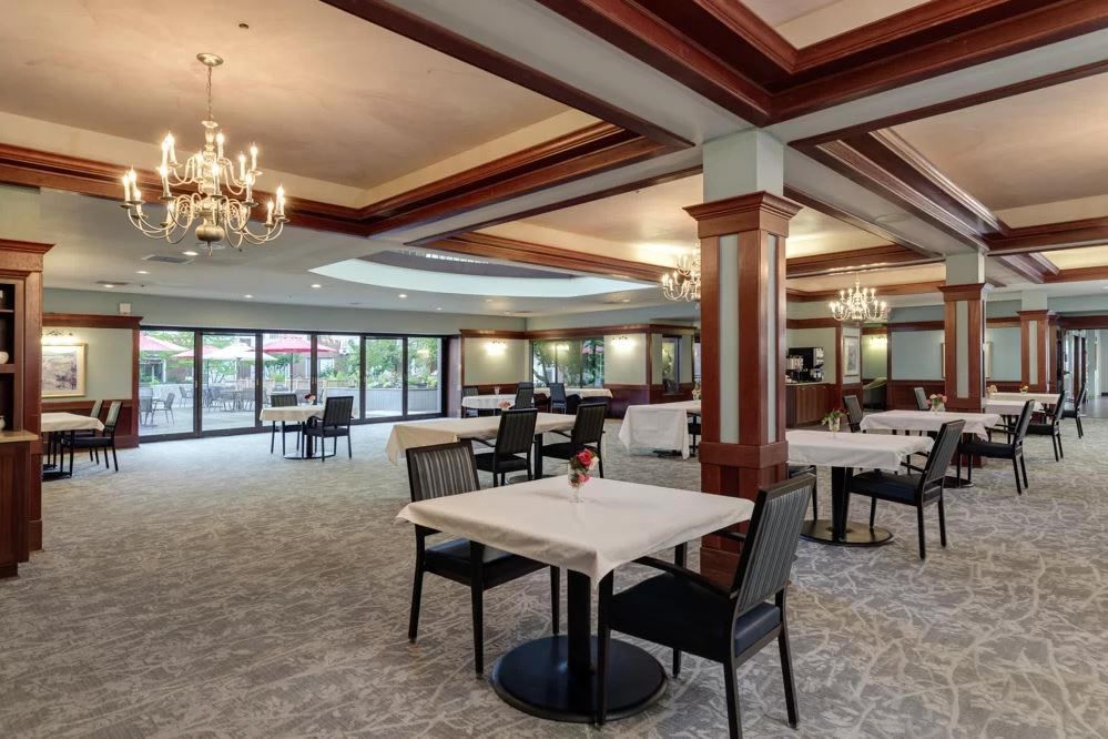Elegant restaurant interior with dining tables, comfortable seating, and chandeliers.