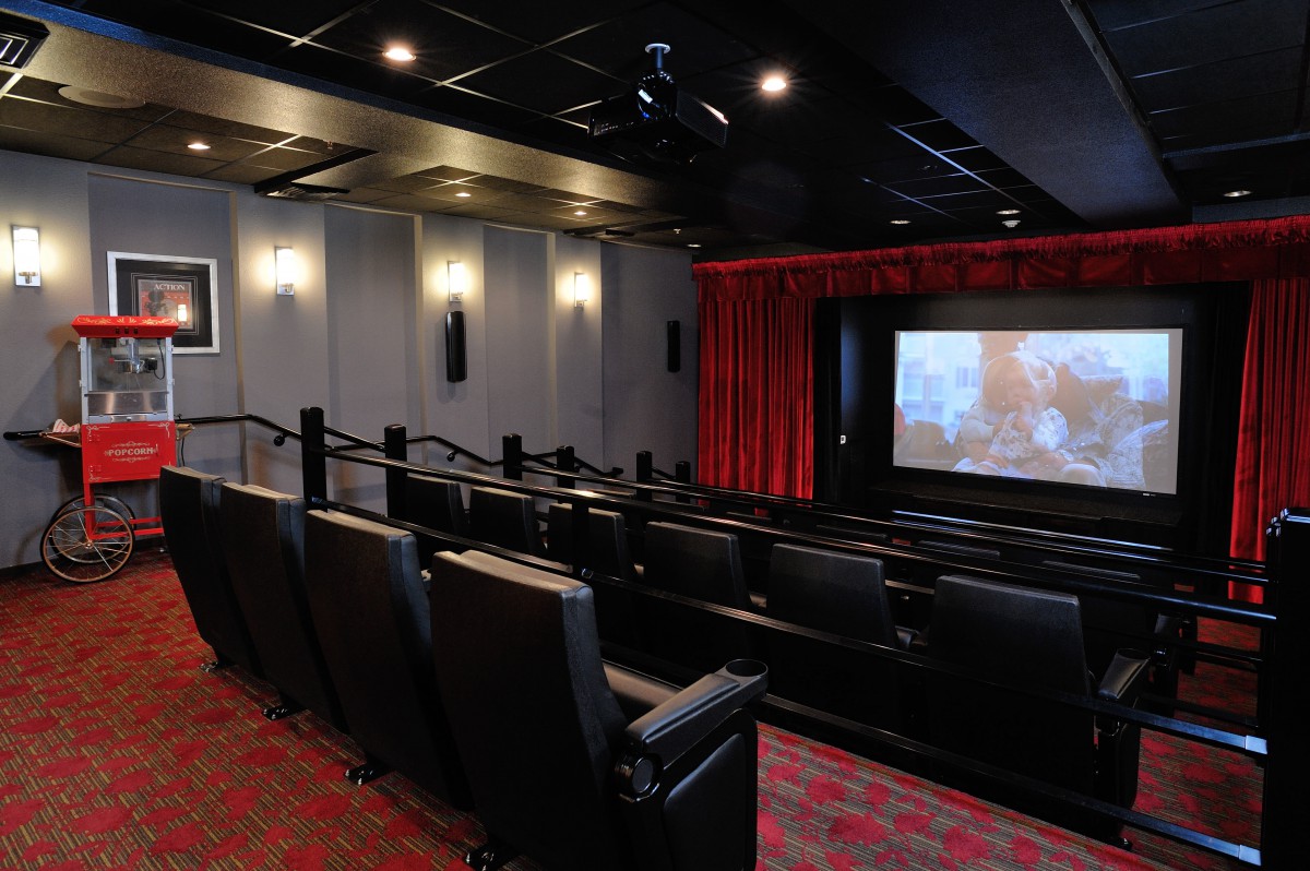 A small, modern movie theater with comfortable seating and a large screen.