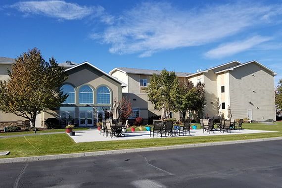 A residential building with landscaped grounds and a clear blue sky.