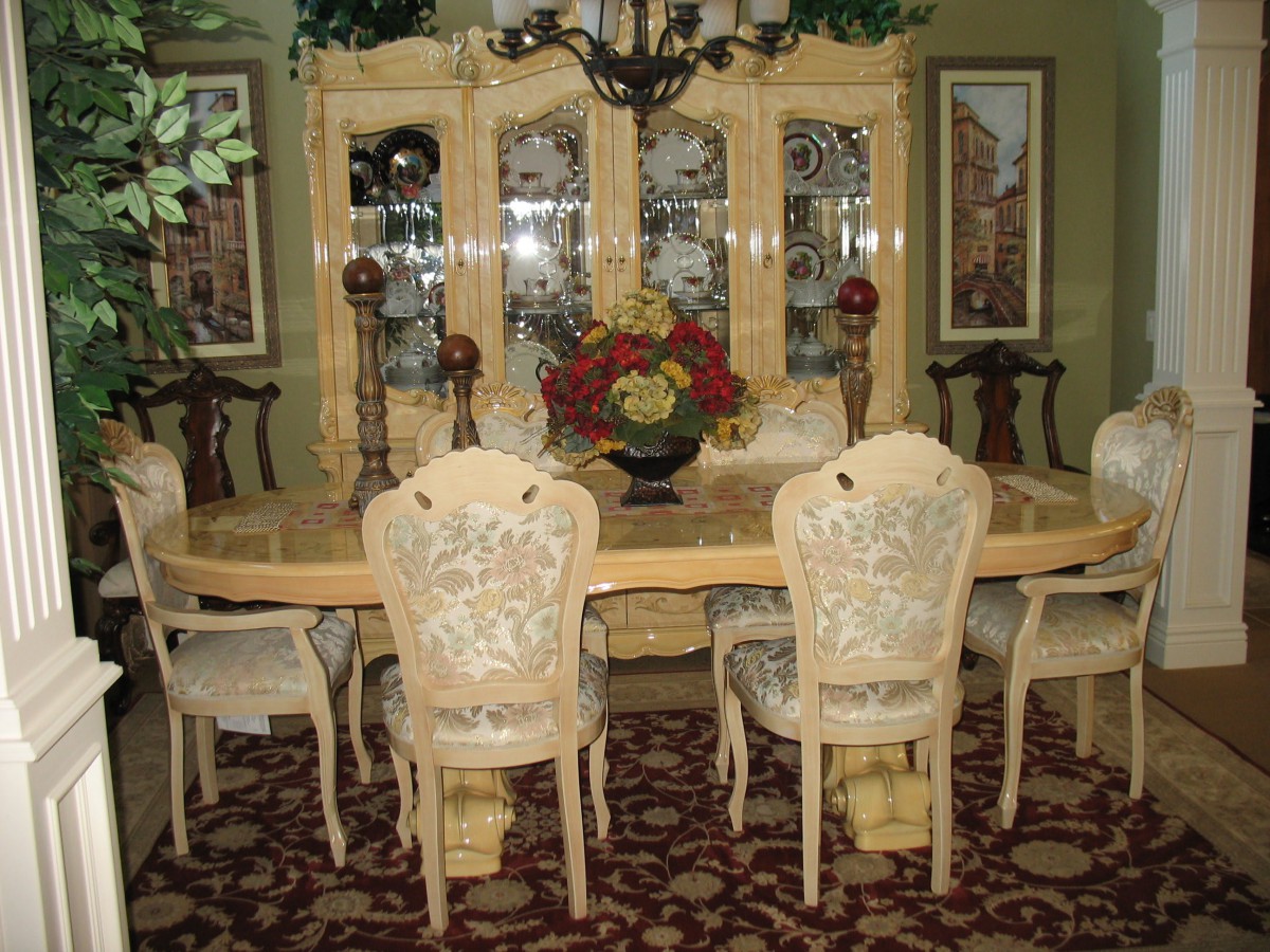 Elegant dining room with a large table, upholstered chairs, and a decorative cabinet.