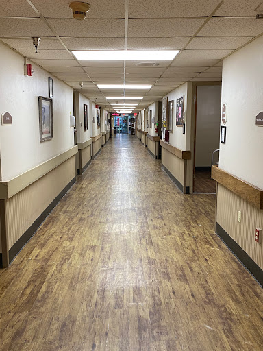 A well-lit hallway featuring artwork along the walls, typical of a medical facility.